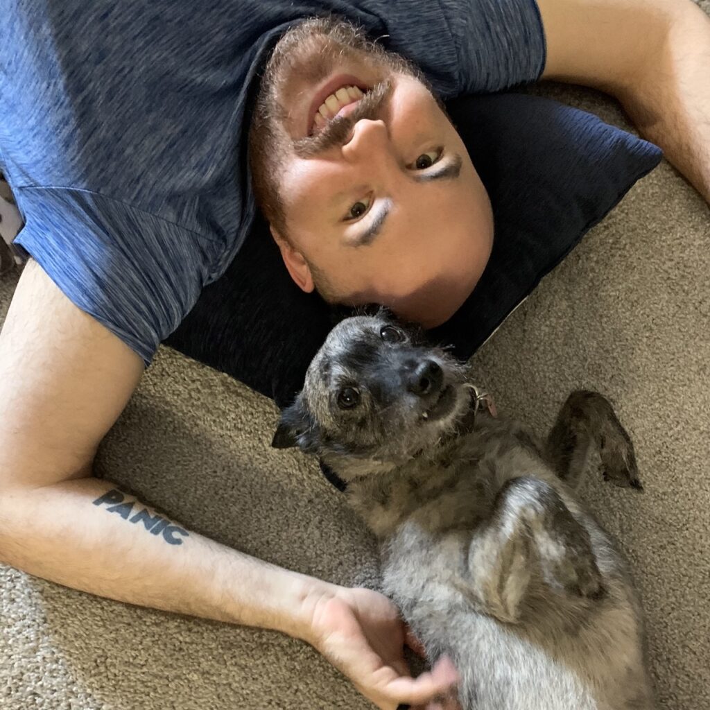 Nicholas lying on the floor with his dog